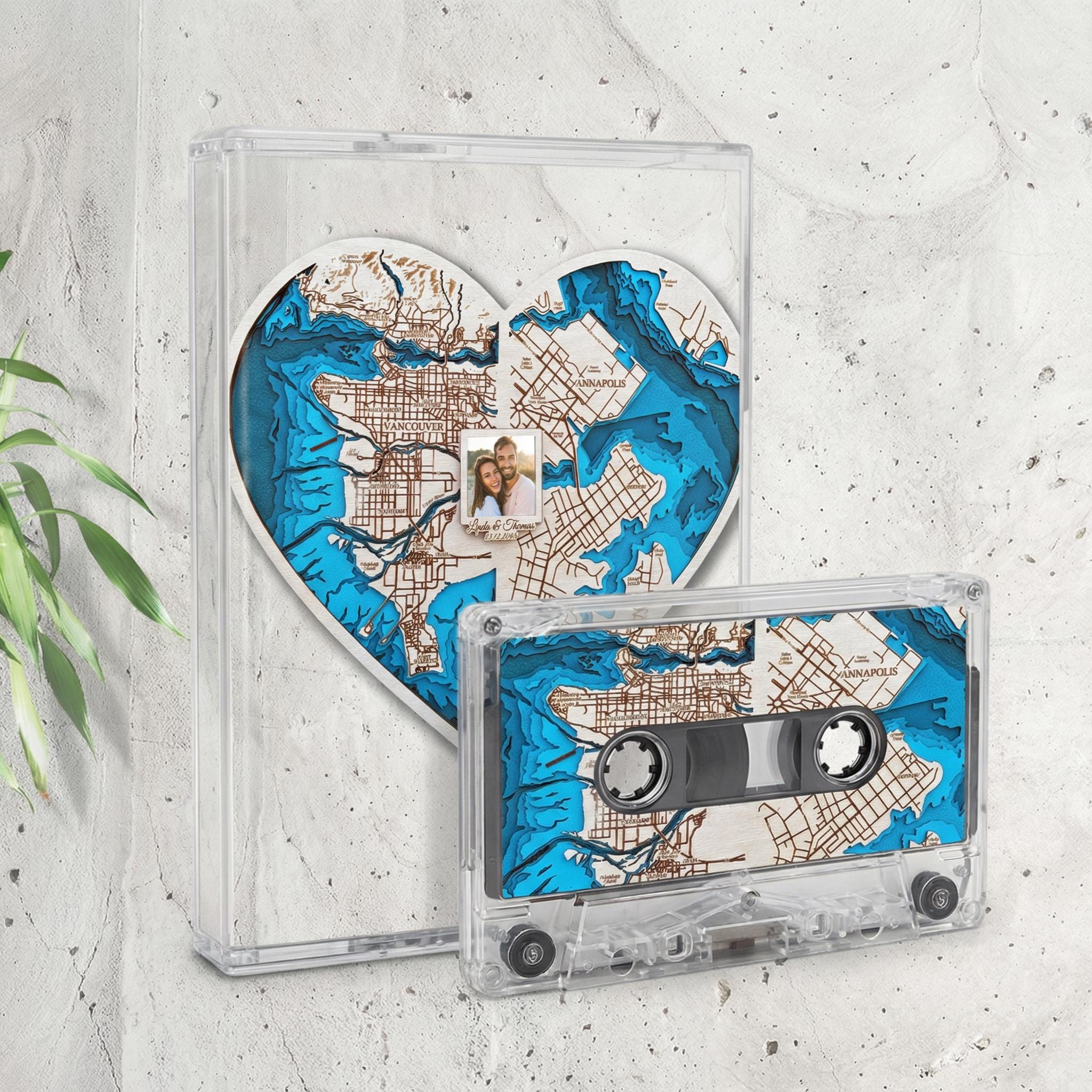 a heart-shaped object with a map of a city, and a cassette tape with a map of the city on it, both displayed against a white wall.