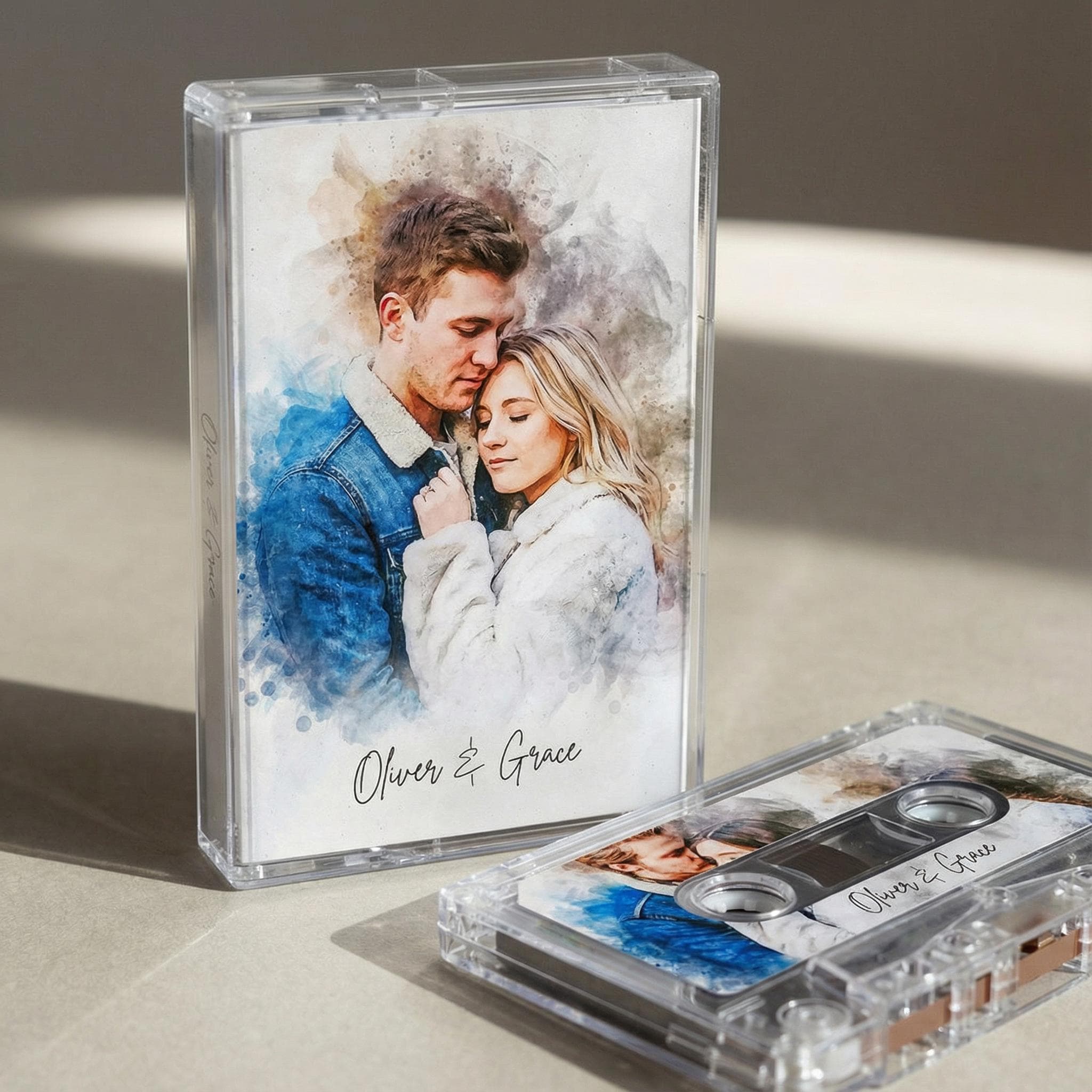 a framed photo of a couple embracing, with the text "Oliver & Grace" written below the image. There is also a cassette tape next to the framed photo, with the text "Oliver & Grace" written on it.